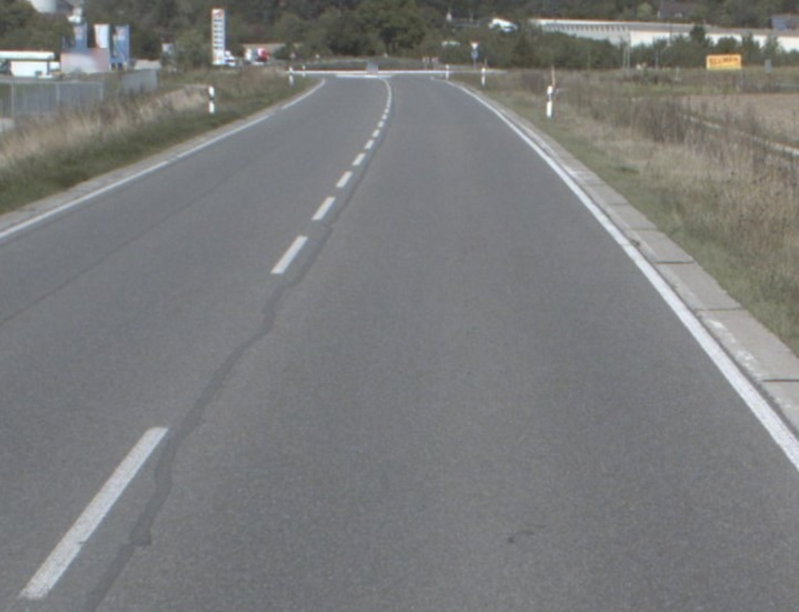 Man blickt auf die Asphaltfläche einer unbefahrenen Straße