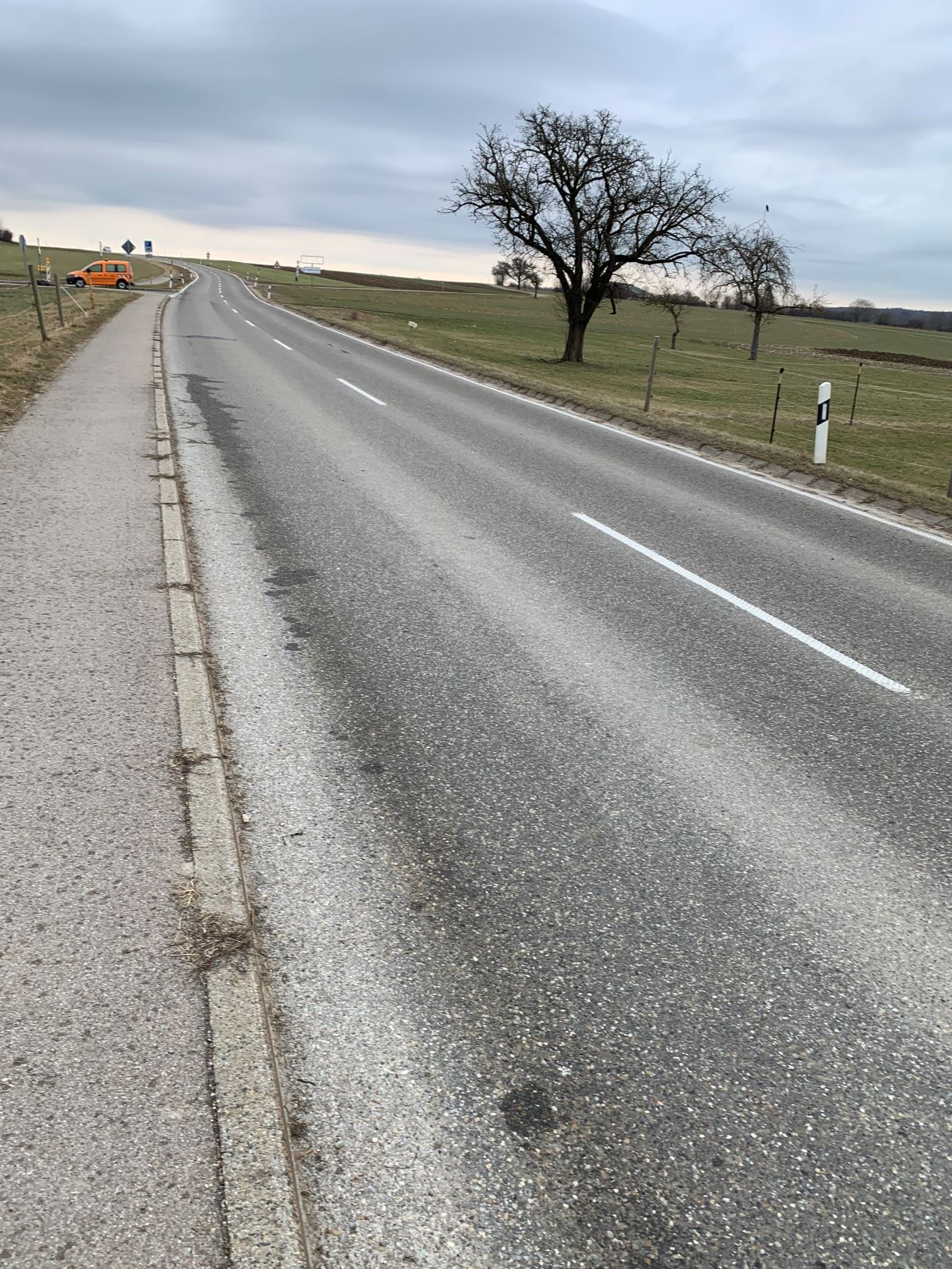 Blick auf eine Landesstraße, die den Berg hinaufführt. Oben links im Bild sieht man ein Fahrzeug der Straßenbauverwaltung.