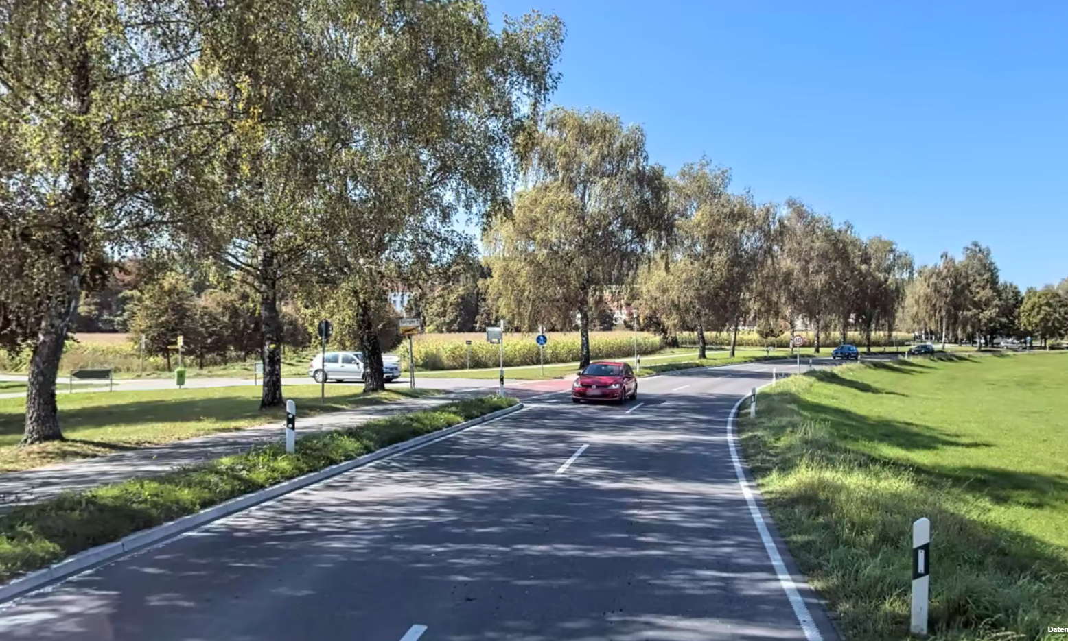 Das Bild zeigt die einseitig von Bäumen gesäumte L 205 mit Autoverkehr.
