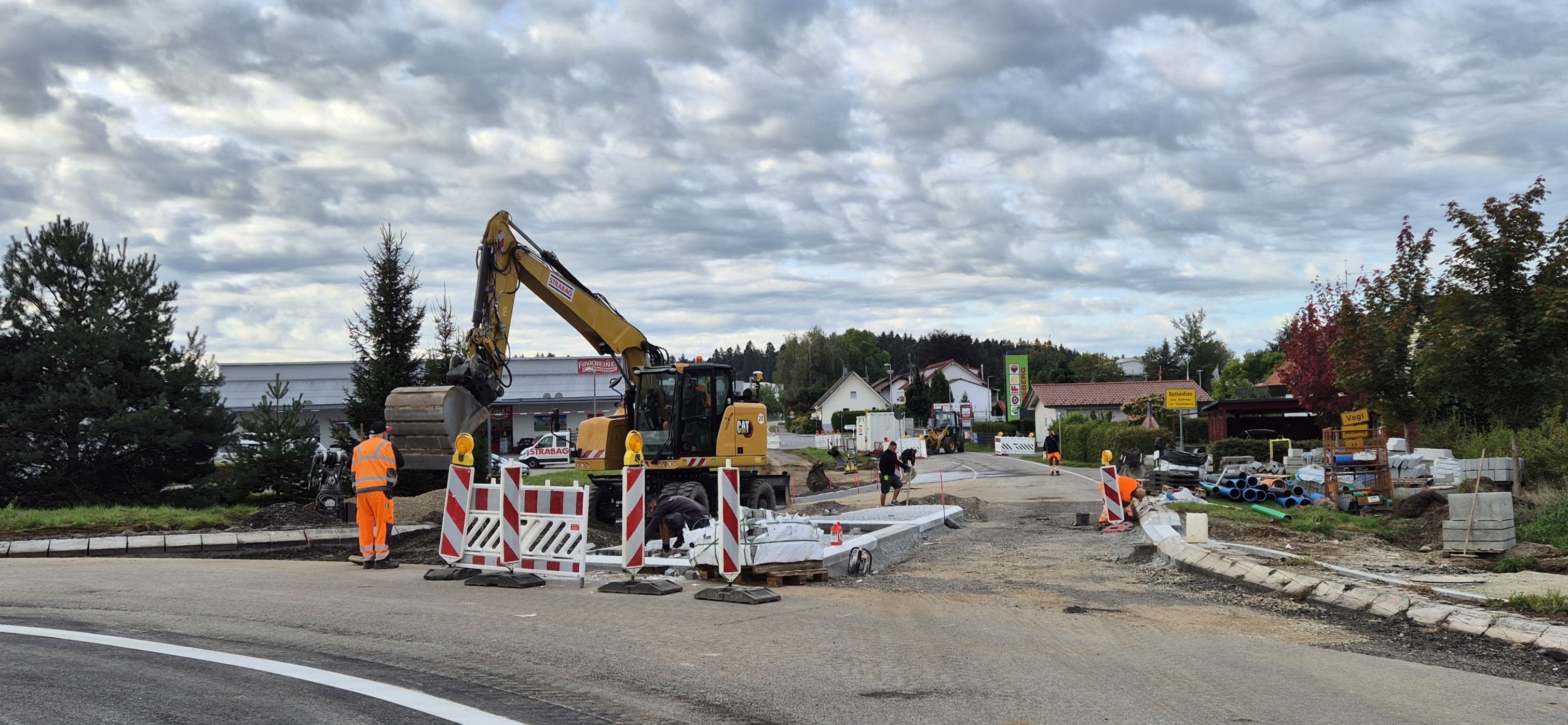 Das Foto zeigt Straßenbauarbeiten an der B 32. Man sieht einen Bagger, die aufgegrabene Fahrbahnoberfläche und mehrere Absperrungen