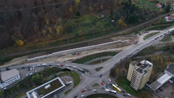 Luftbild einer Straßenbaustelle mit einem tiefen Einschnitt in einen Hang. 