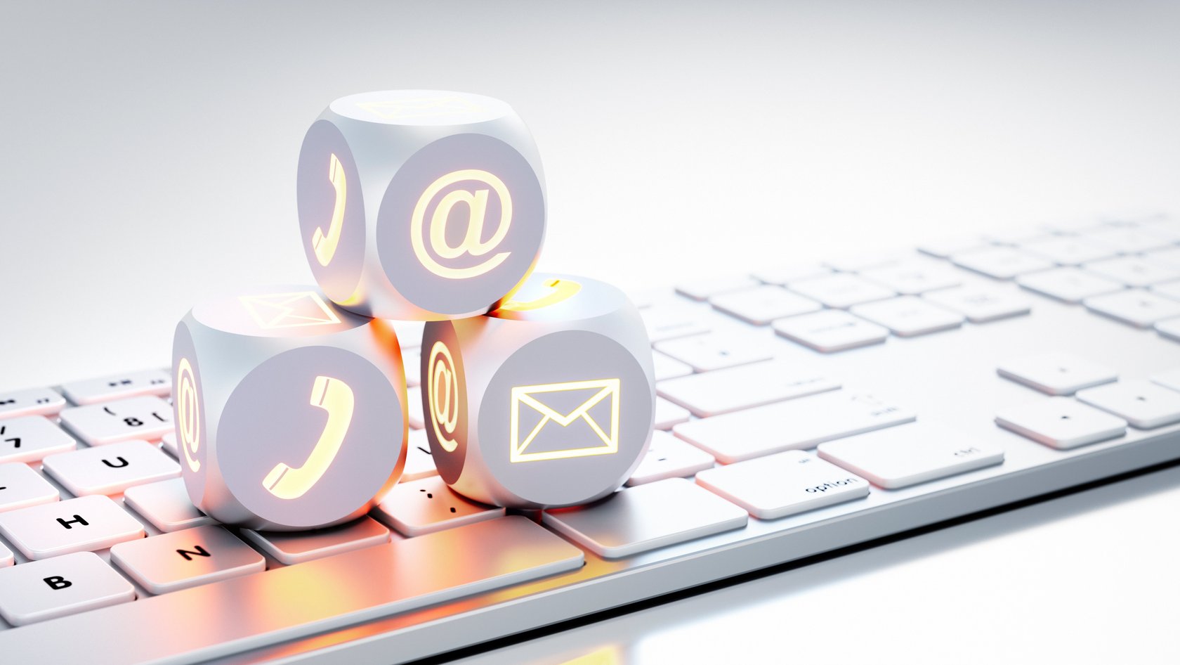 Auf einer Tastatur sind drei Würfel mit Kommunikationszeichen aufeinander aufgebaut