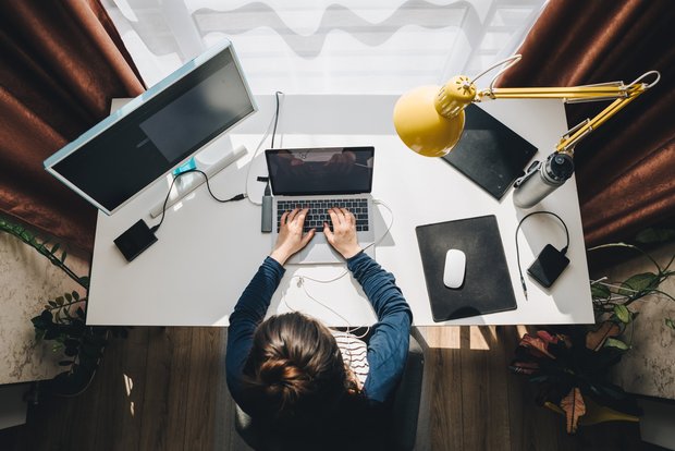 Homeoffice Eine junge Frau am Arbeitsplatz von oben betrachtet