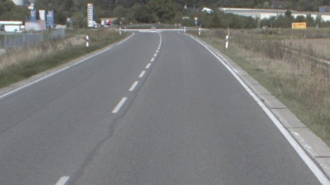 Man blickt auf die Asphaltfläche einer unbefahrenen Straße