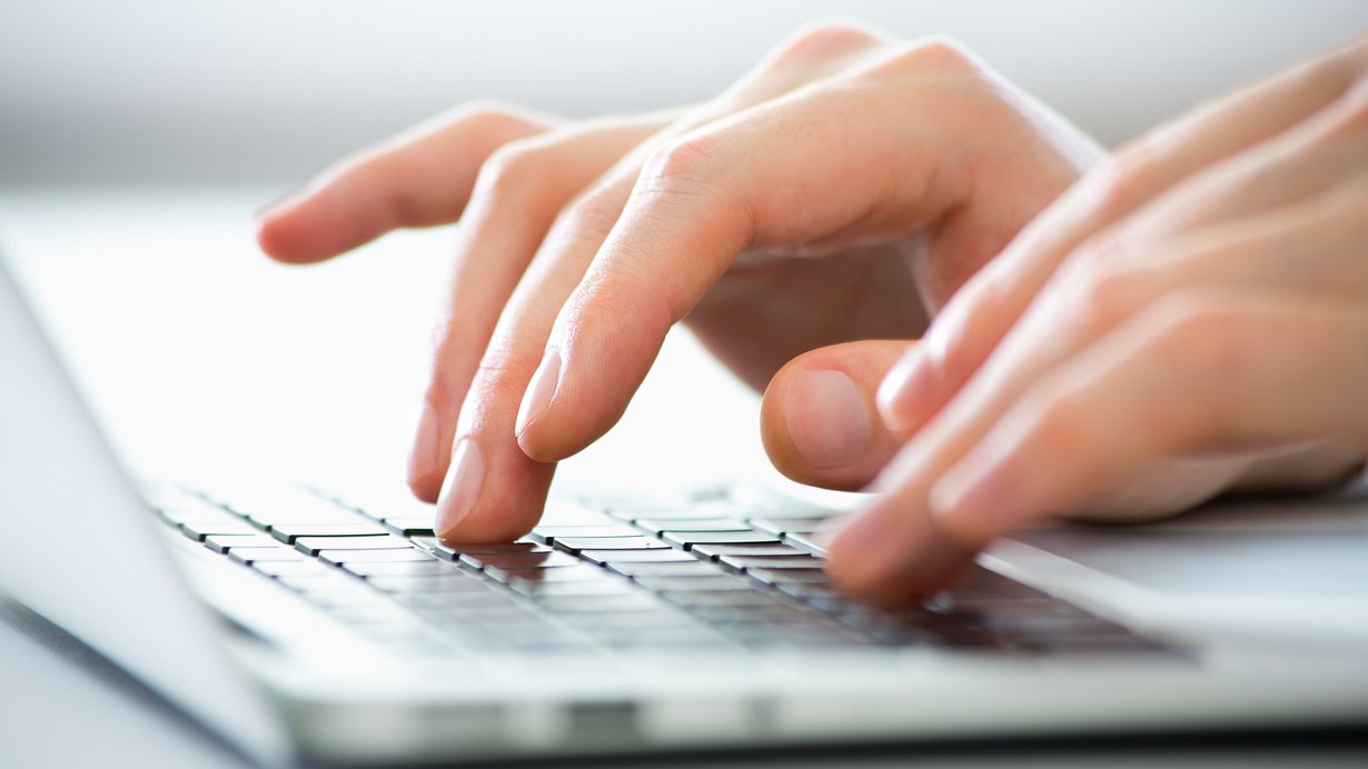 Nahaufnahme der Hände des Lehrers, der auf einem Laptop tippt