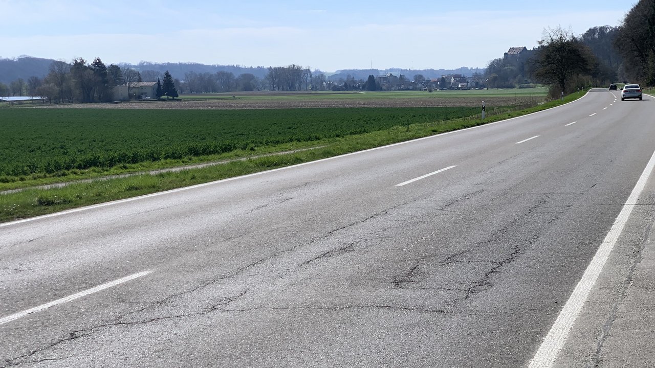 Das Foto zeigt die schadhafte Fahrbahndecke der B 465 zwischen Warthausen und Schemmerhofen. Im Hintergrund sieht man Häuser