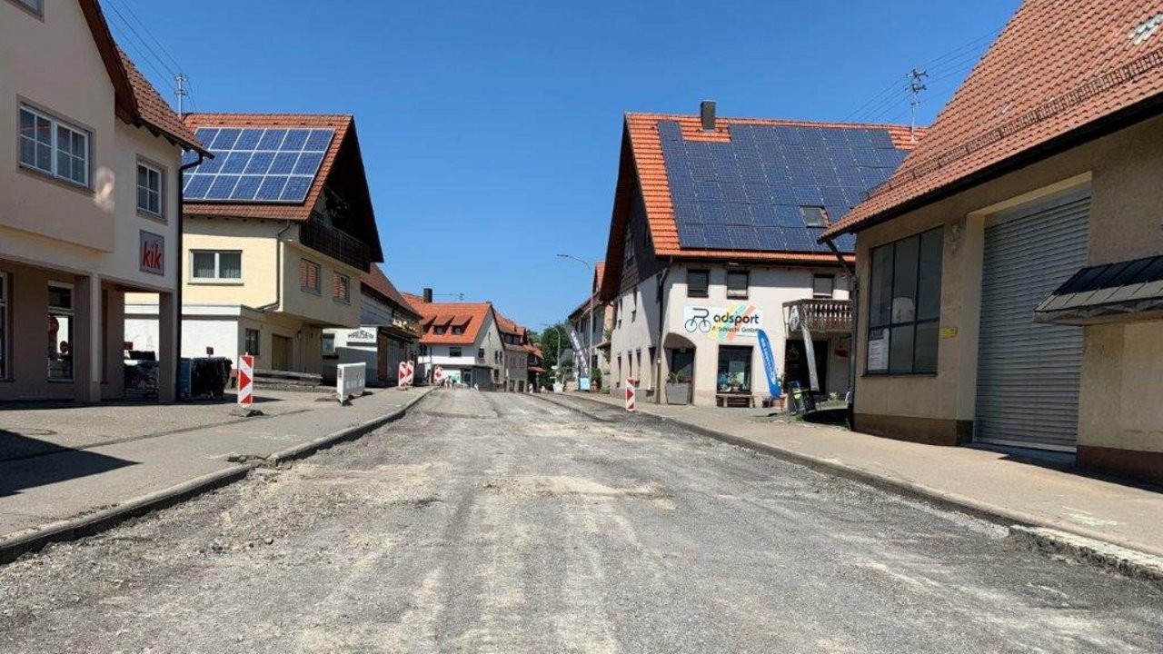 Das Foto zeigt Fahrbahndeckenerneuerung die Ortsdurchfahrt von Geislingen im Verlauf der L 415. Rechts und links der maroden Ortsdruchfahrt stehen Häuser.