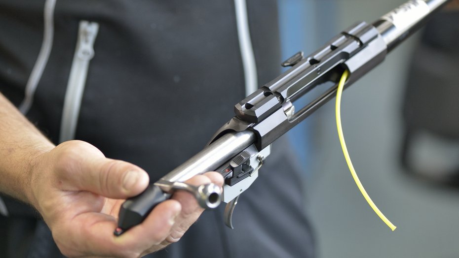 Teil einer Schusswaffe Ein Mann hält einen teil einer schusswaffe in der Hand