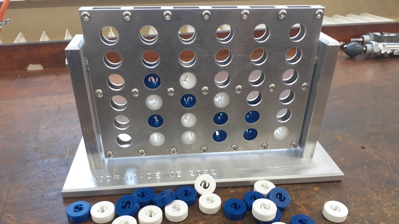 Vier-Gewinnt-Spiel Das Bild zeigt ein Vier-Gewinnt-Spiel aus Metall mit weißen und roten Spielteilen