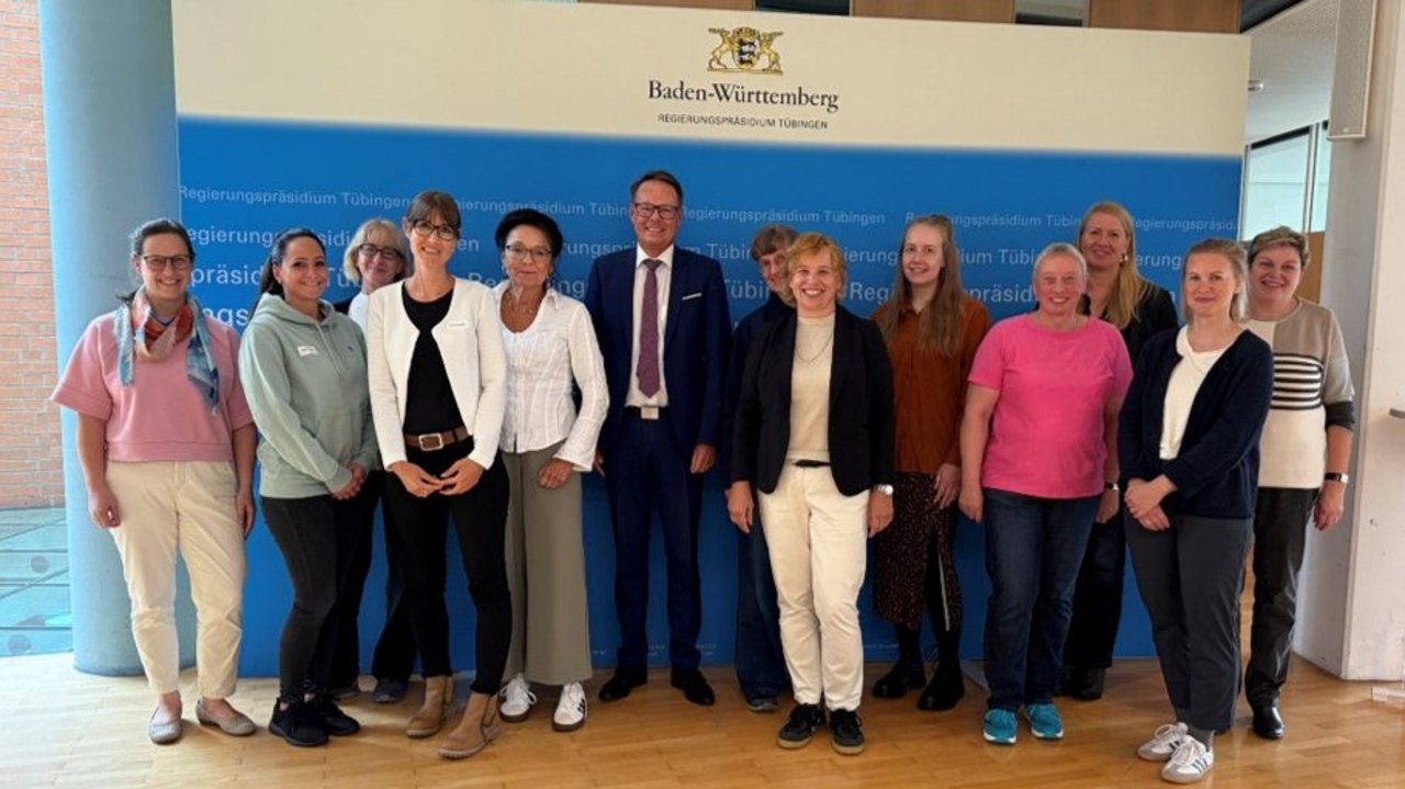 Eine Gruppe von Frauen und Männer, Vertreterinnen und Vertreter der Hauswirtschaftsausbildung aus dem gesamten Bundesgebiet, gemeinsam mit Regierungspräsident Klaus Tappeser lächeln in die Kamera