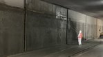 Ein Arbeiter sprüht Beton auf die Innenwand eines Tunnels. 