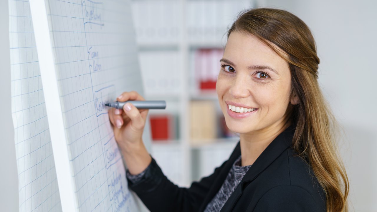 Frau steht am Flipchart