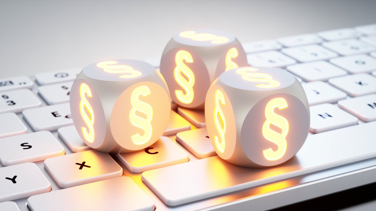 Drei weiße Würfel mit Paragraphensymbol liegen auf einer Tastatur