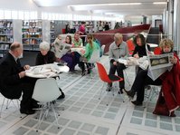 Menschen sitzen im Lesecafé der Stadtbücherei Mössingen in der Tonnenhalle