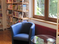 Leseplatz mit blauem Sessel und Glastisch in der Stadtbücherei Albstadt - Zweigstelle Tailfingen