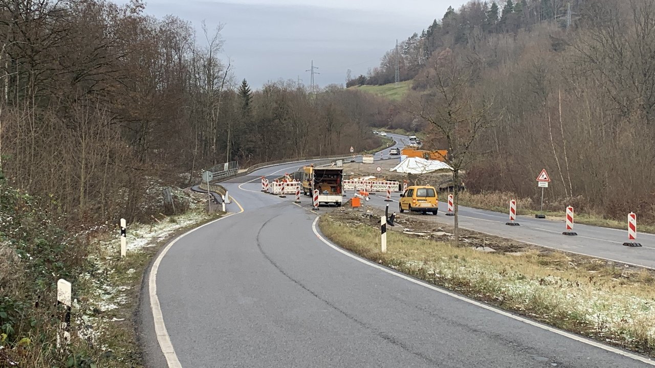Das Foto zeigt die Baustelle B 463 zwischen Balingen-Dürrwangen und Albstadt-Laufen. Man sieht mehrere Absperrungen, Leitbaken ein Baustellenschild und die neu instandgesetzte Fahrbahn in einem Waldstück.
