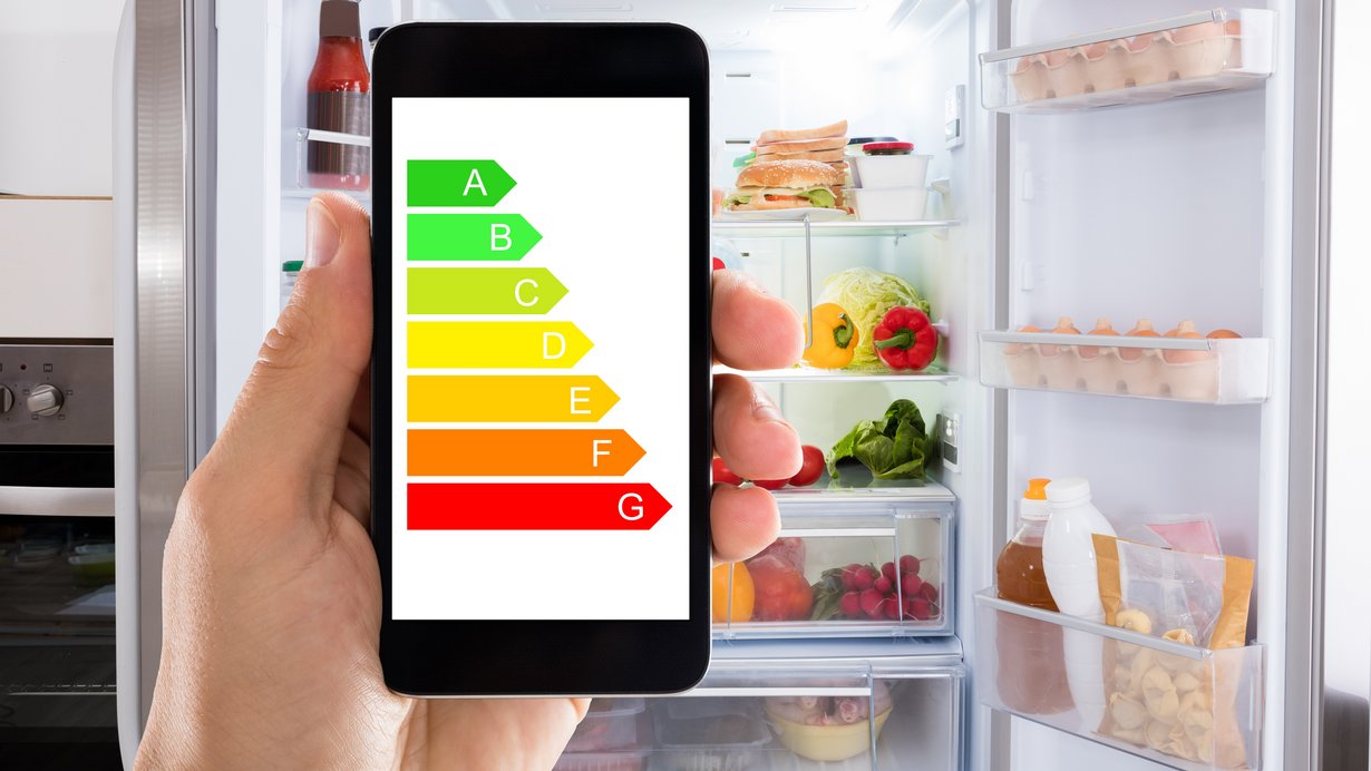 Eine Hand zeigt ein handy mit einem Energielabel