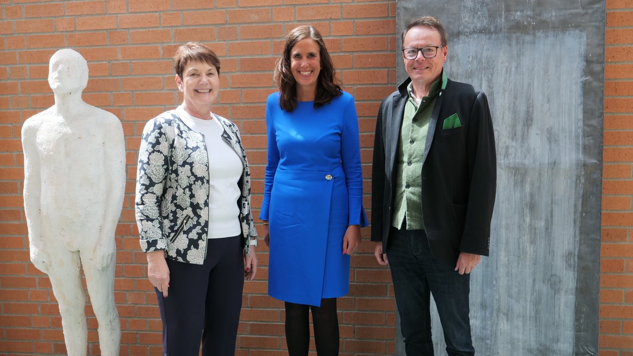 Frau AP Pacher, Frau Lenz, Herr RP Tappeser stehen nebeneinander und lächeln in die Kamera.