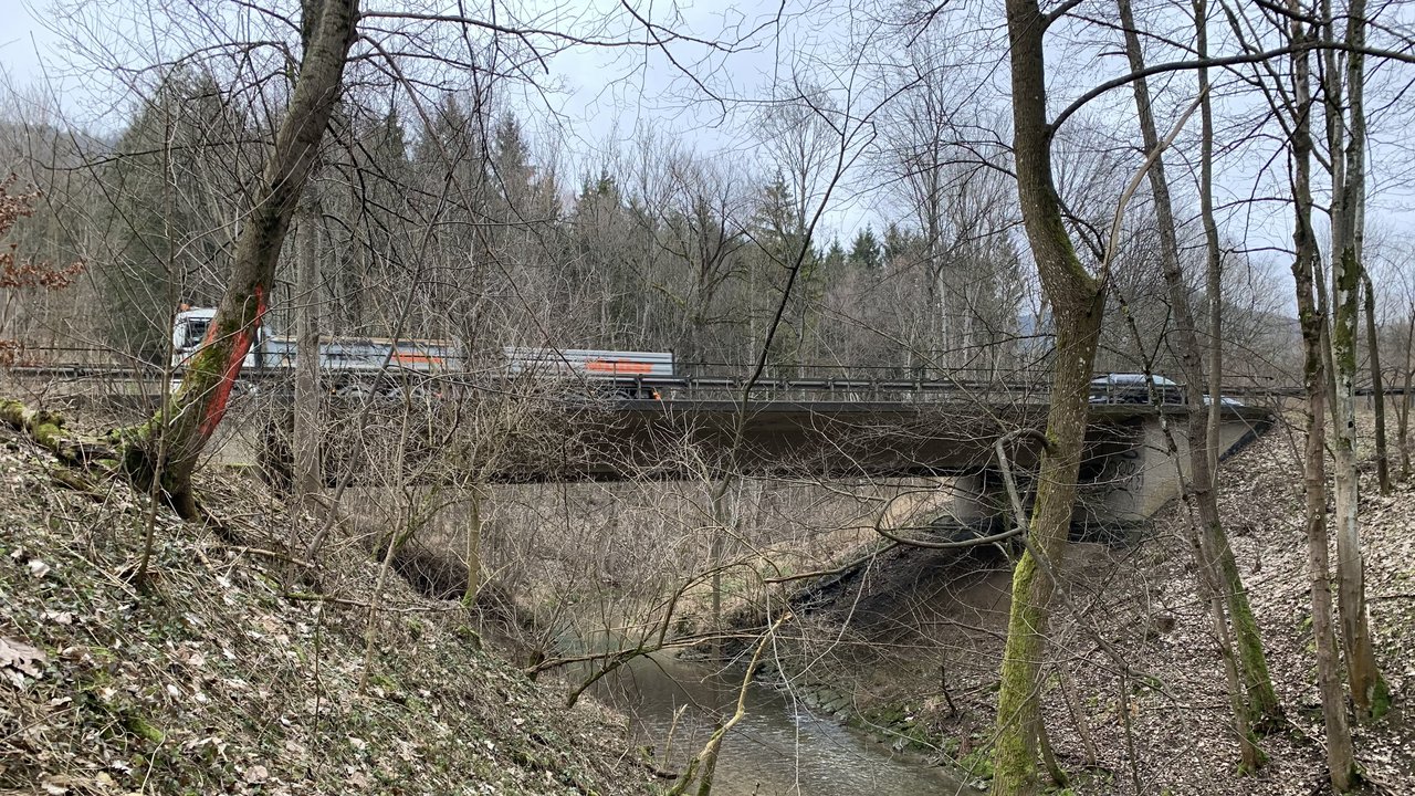 Ein Lastwagen fährt über eine Brücke über die Eyach