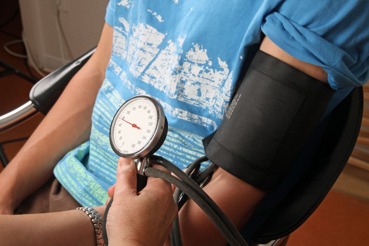 Einem jungen Mann wird der Blutdruck gemessen