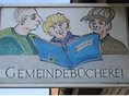 Gemeindebücherei Wilhelmsdorf - Aushängschild Gemeindebücherei Wilhelmsdorf - Aushängschild: Zeichnung mit 3 Jungs, die in ein Buch schauen