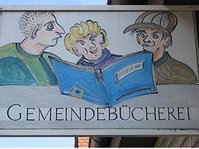 Gemeindebücherei Wilhelmsdorf - Aushängschild: Zeichnung mit 3 Jungs, die in ein Buch schauen