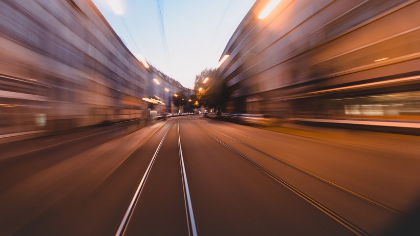 Sonderfahrt mit der S1 durch Ulm, man blickt aus dem Führerhaus der Bahn und sieht vorbeiziehende Häuserfronten (unscharf), Abendstimmung