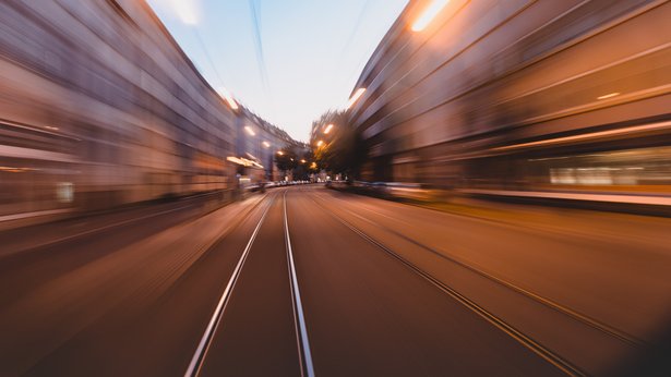 Sonderfahrt mit der S1 durch Ulm, man blickt aus dem Führerhaus der Bahn und sieht vorbeiziehende Häuserfronten (unscharf), Abendstimmung