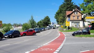 Eine Straße und ein Radweg. Auf der Fahrspur, die Richtung Kamera führt, stehen mehrere Fahrzeuge