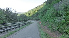 Ein Radweg und eine Straße, die steil bergab führen und in eine Haarnadelkurve münden