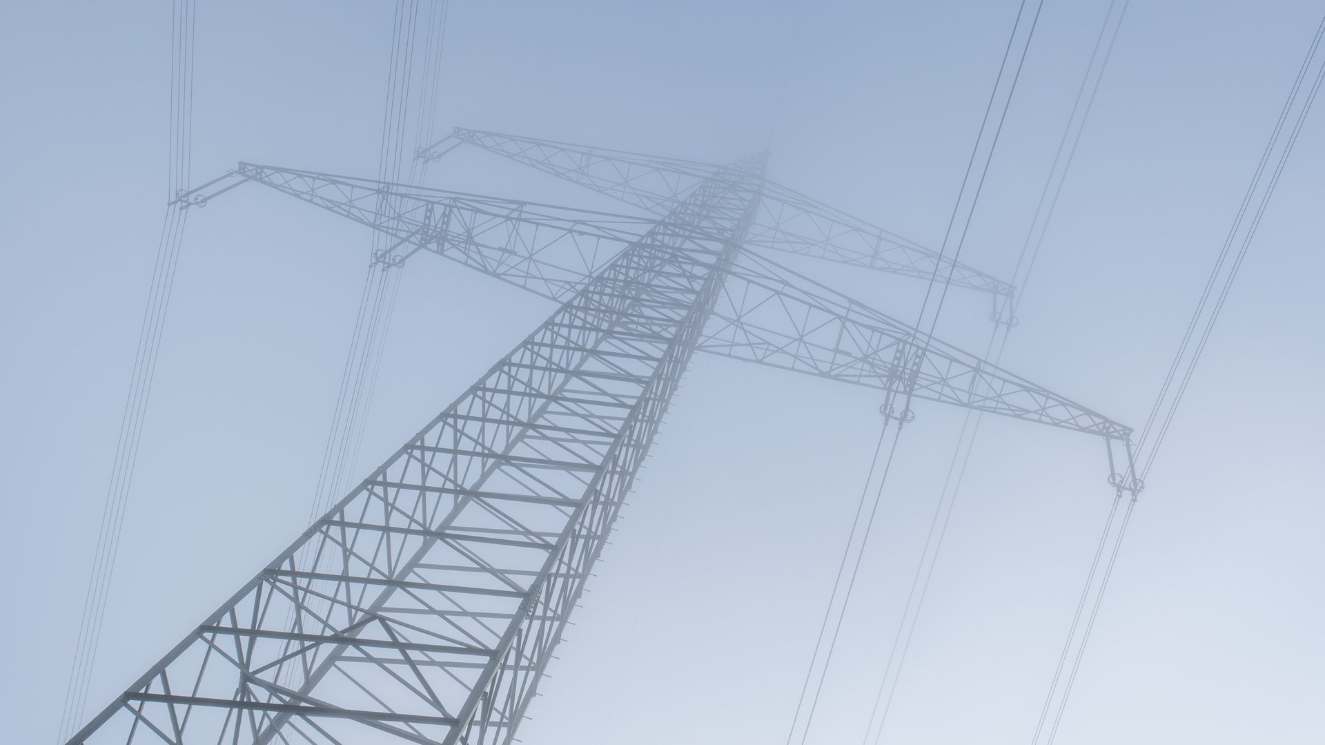Das Foto zeigt einen Höchstspannungsmast im Nebel