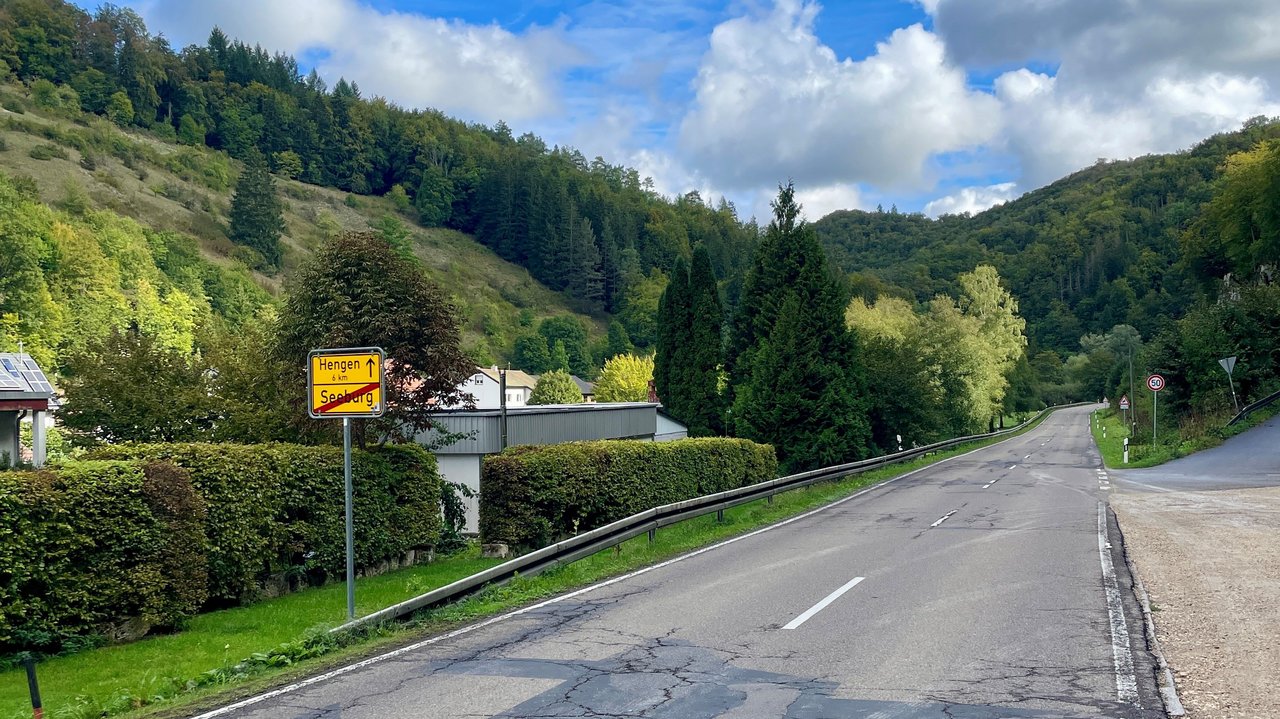 Das Foto zeigt die L 245 Bad Urach in Richtung Hengen. Man sieht das Ortsausgangsschild und einzelne Häuser von Seeburg.
