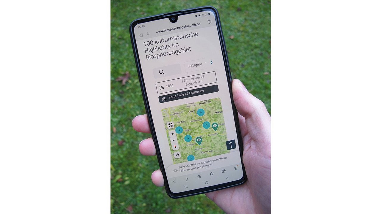 Das Foto zeigt ein Smartphone mit der Online-Sammlung der 100 historisch-kultureller Highlights im Biosphärengebiet