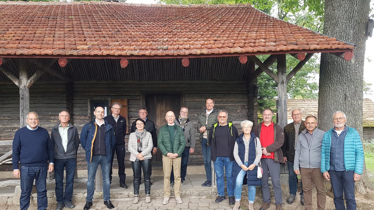 Im Bild stehen die Naturschutzbeaufragten gemeinsam mit dem Rgeirungspräsidenten und Vertreterinnen und Vertretern des Regierungspräsidums Tübingen vor einer Hütte im Wald.