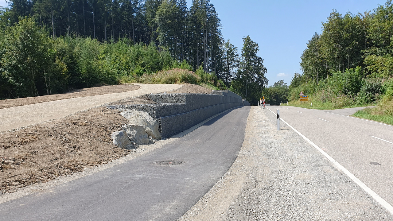 Ein frisch asphaltierter Radweg entlang einer Straße
