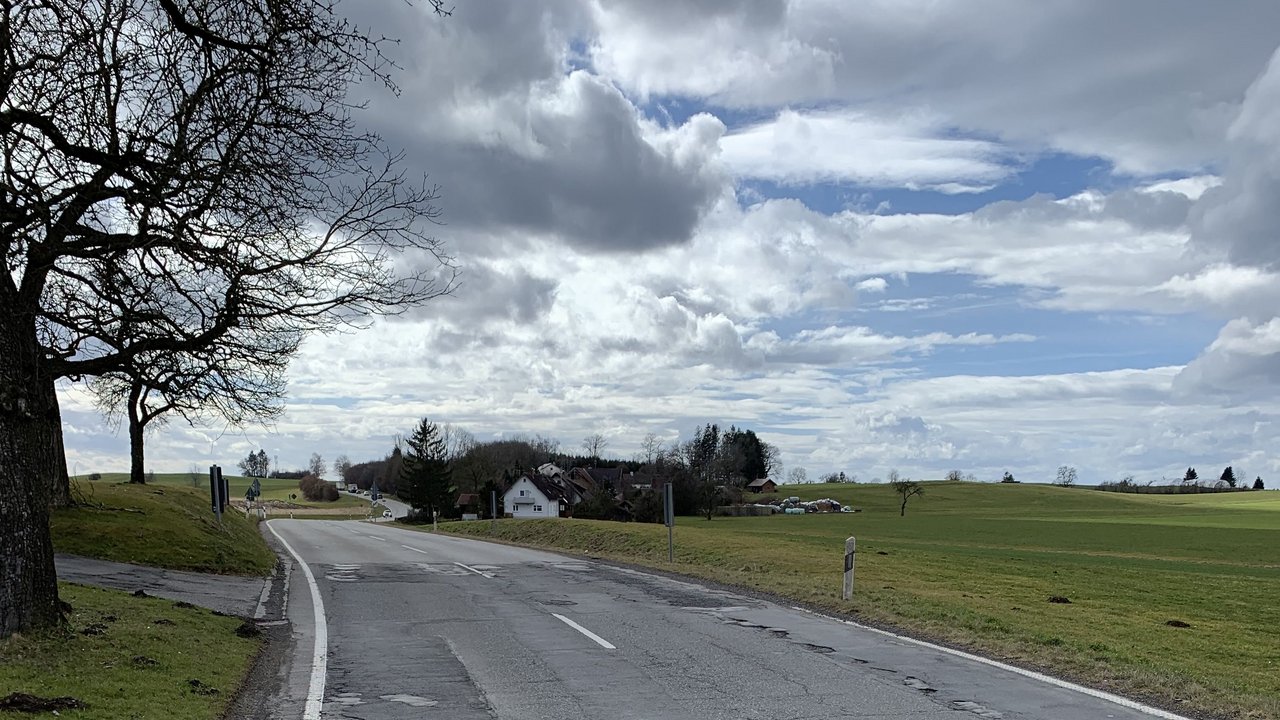 Das Foto zeigt die L 314 zwischen Bergatreute und Roßberg (Wolfegg); links und rechts Wiesen im Hintergrund ein Gebäude
