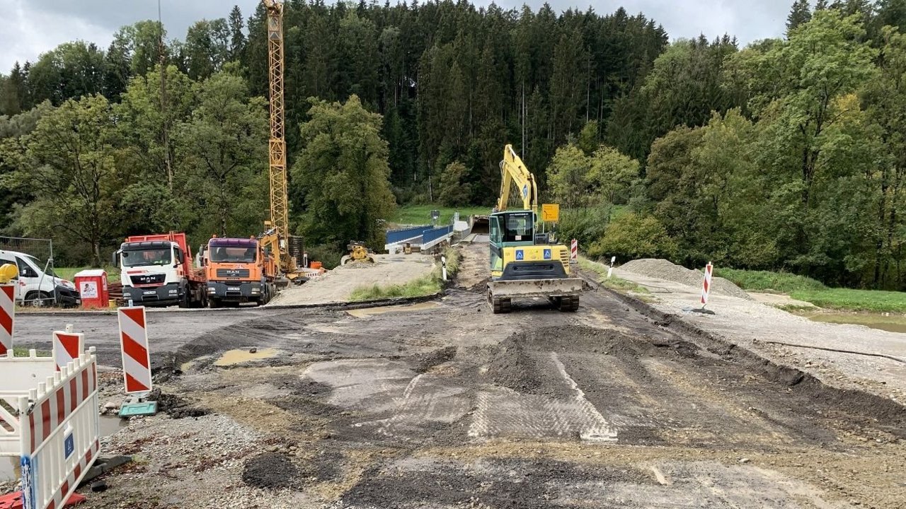 Das Bild zeigt die abgefräste L 333 mit in Bau befindlicher Radwegbrücke; Baustellenfahrzeuge; Wald im Hintergrund