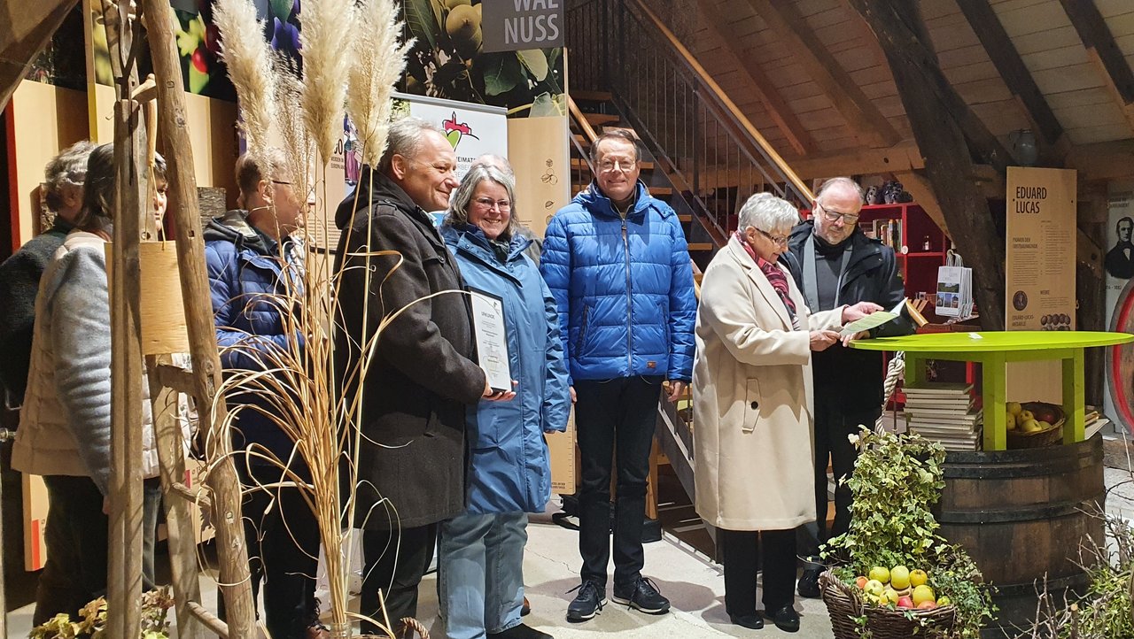 Das Foto zeigt Herrn Regierungspräsident Klaus Tappeser und andere bei der Preisverleihung des Museumswettebewerb 2024 im Obstbaumuseum Glems