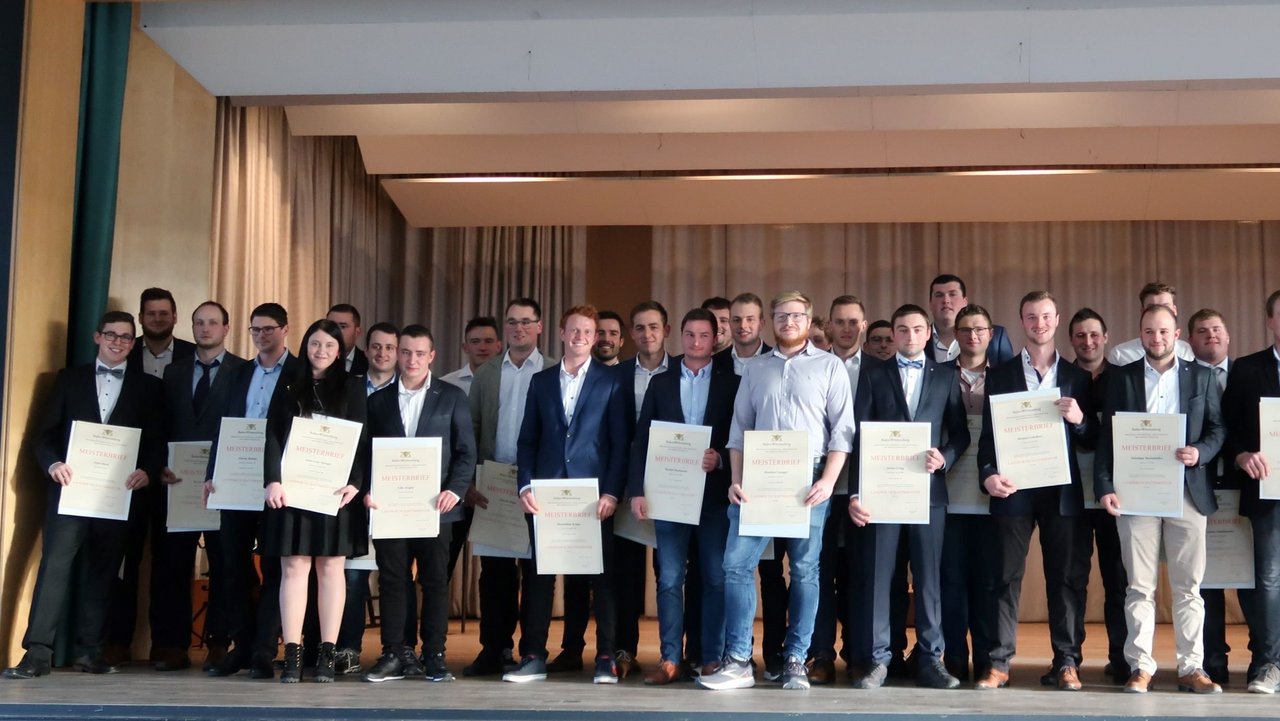 Das Bild zeigt ein Gruppenbild mit einer Landwirtschaftsmeisterin und mehreren Landwirtschaftsmeistern mit Ihren Urkunden in den Händen
