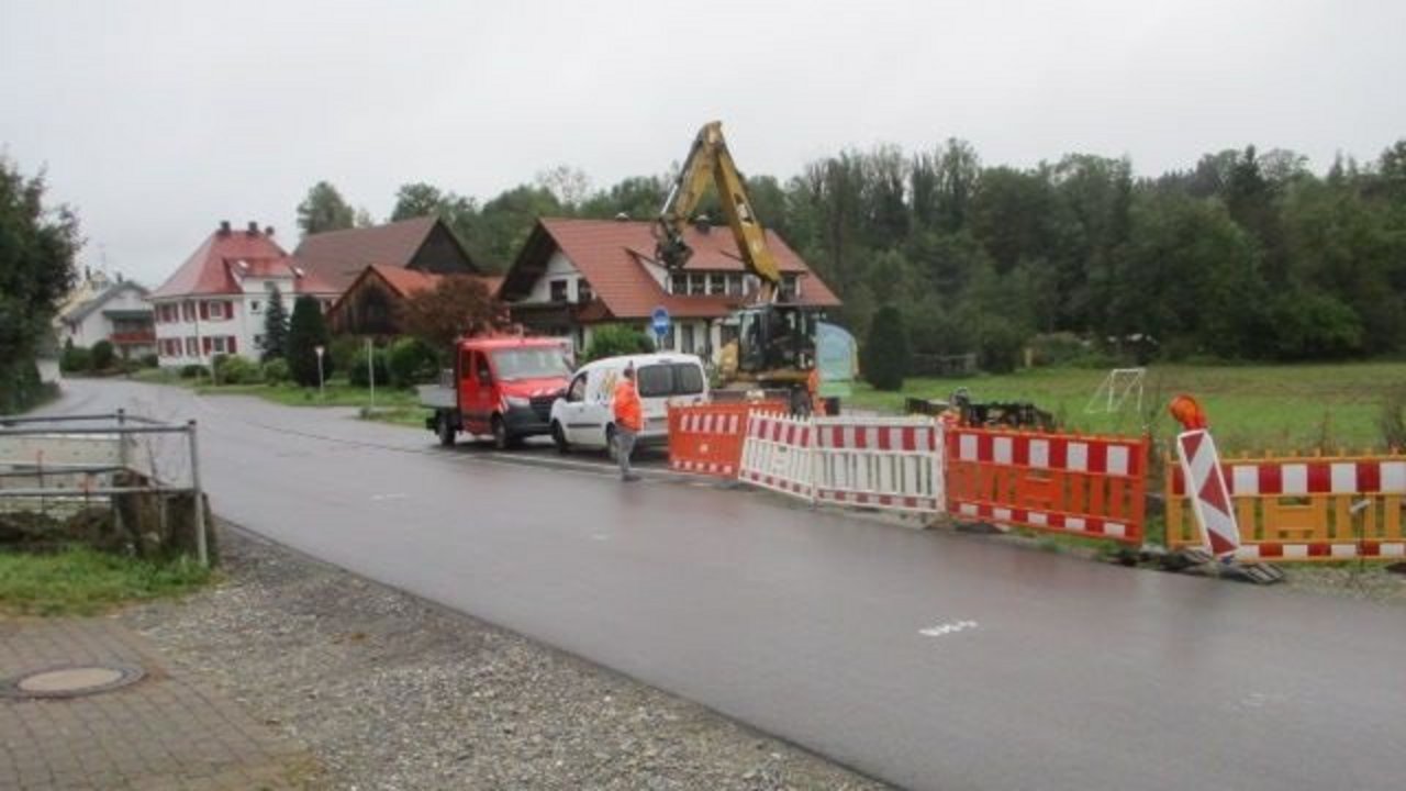 Straßenabsperrungen am Schupelbachdurchlass; im Hintergrund sieht man Urnau