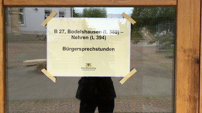 Ein Schild mit dem Hinweis zur Bürgersprechstunde klebt an der Eingangstür