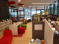 Bibliotheksraum der Mediathek am Teuringer, Oberteuringen, mit weißen Regalen, bunten Sitzmöbeln