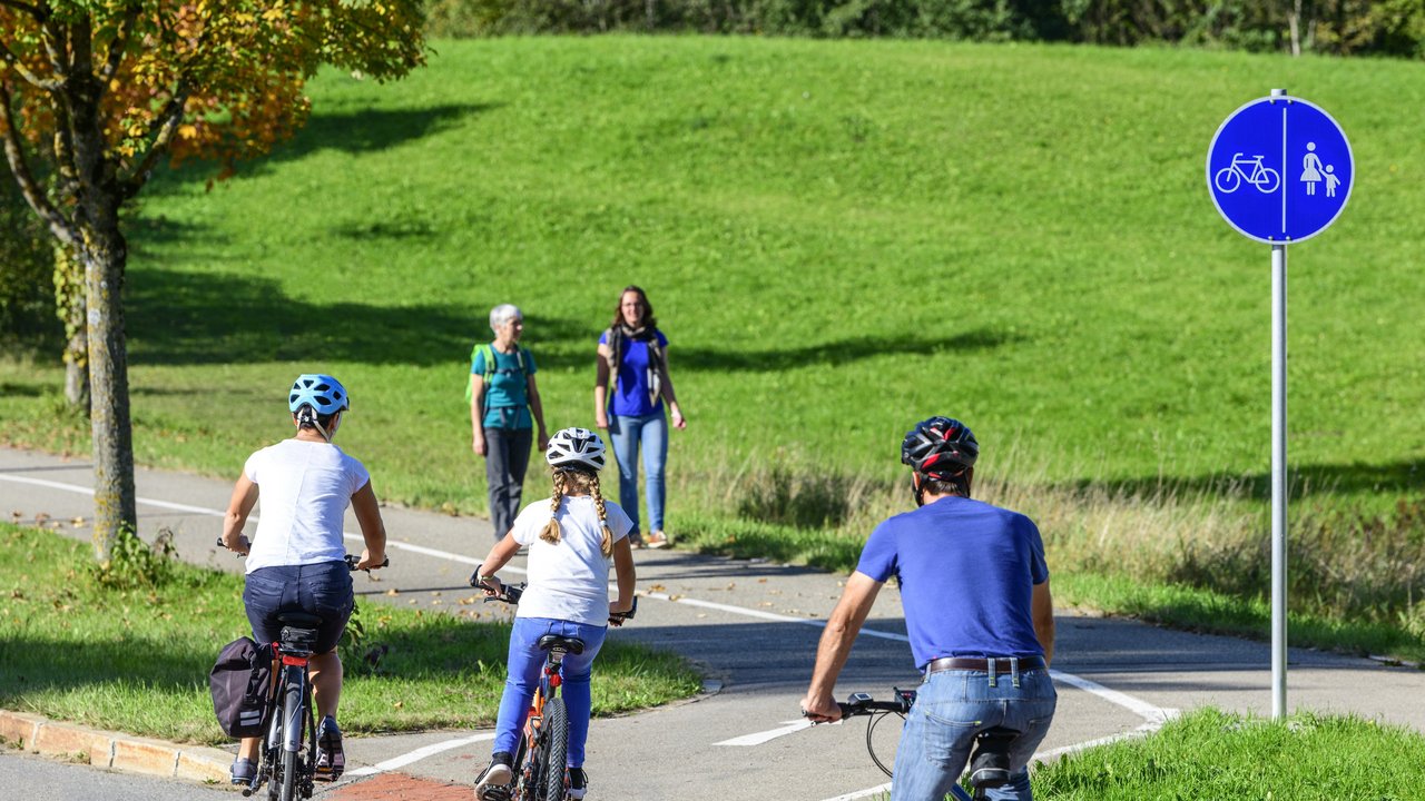 Radfahrer befahren einen Übergang von der Straße auf einen kombinierten Rad- und Fussweg