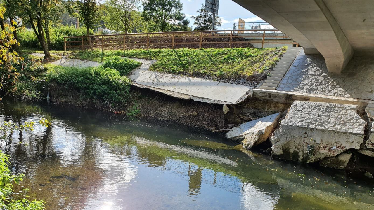 Das Bild zeigt die Böschung an der Echaz nach Hochwasserschaden; Abgebrochene Beton-Teile unter einer Brücke