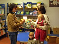 Büchereileitung und Leserin mit zwei Kindern im Beratungsgespräch in der Gemeindebücherei Starzach