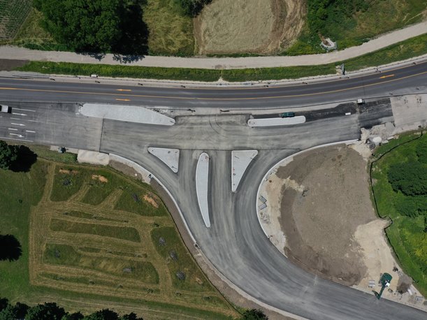 Luftbild einer Straßenkreuzung, auf der keine Markierungen angebracht sind. Auf den Mittelinseln zwischen den Fahrstreifen sind weder Schilder noch Ampeln sichtbar