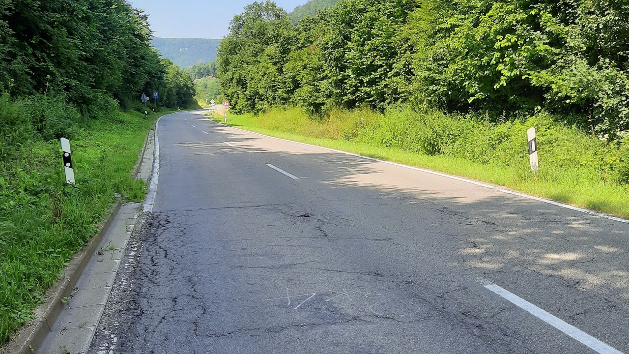 L 211 zwischen Bad Urach und Grabenstetten; man sieht die sanierungsbedürftige Fahrbahn mit Rissen und Wälder im Hintergrund und links und rechts der Fahrbahn