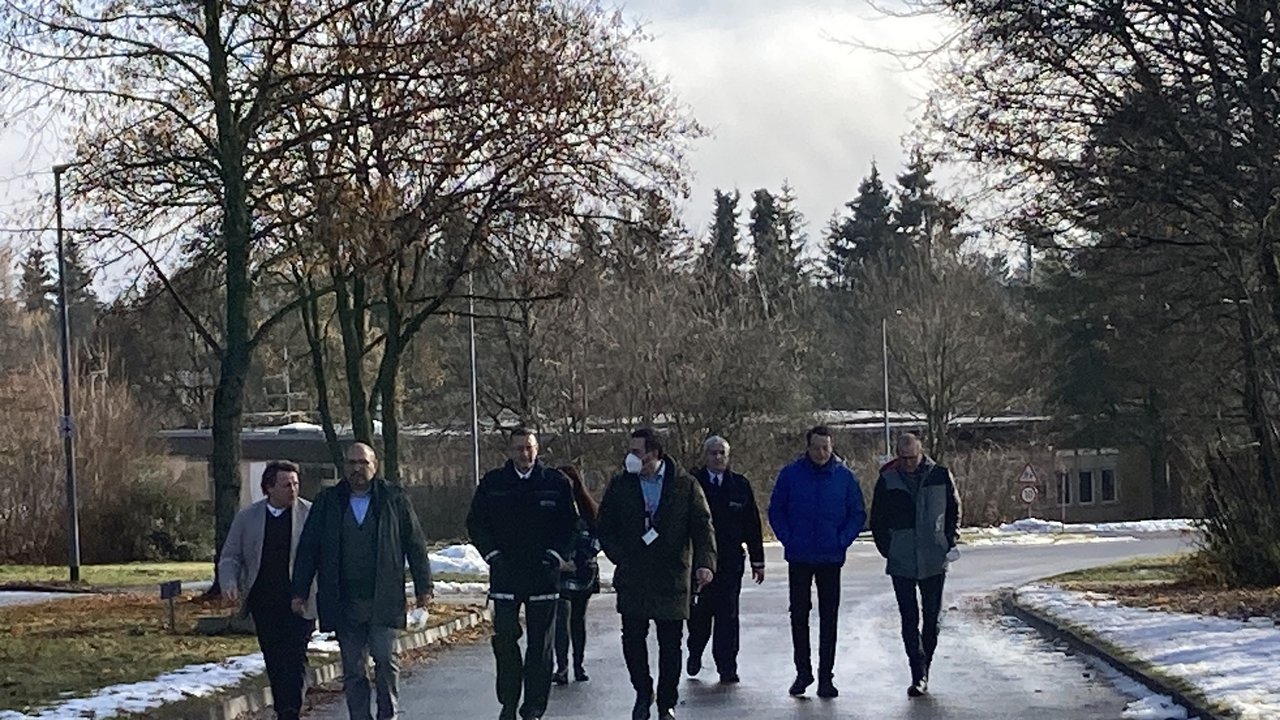 Regierungspräsident Tappeser im Gespräch mit Verantwortlichen in der LEA Sigmaringen - sie laufen einen Weg auf dem Gelände der LEA entlang.