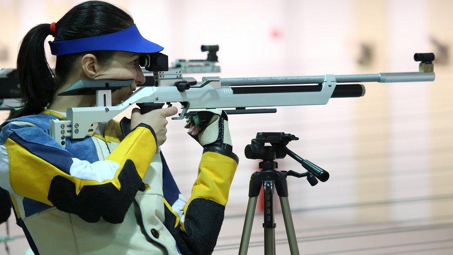 Sportschützin Eine Sportschützin zielt mit einem Luftgewehr auf eine Zielscheibe