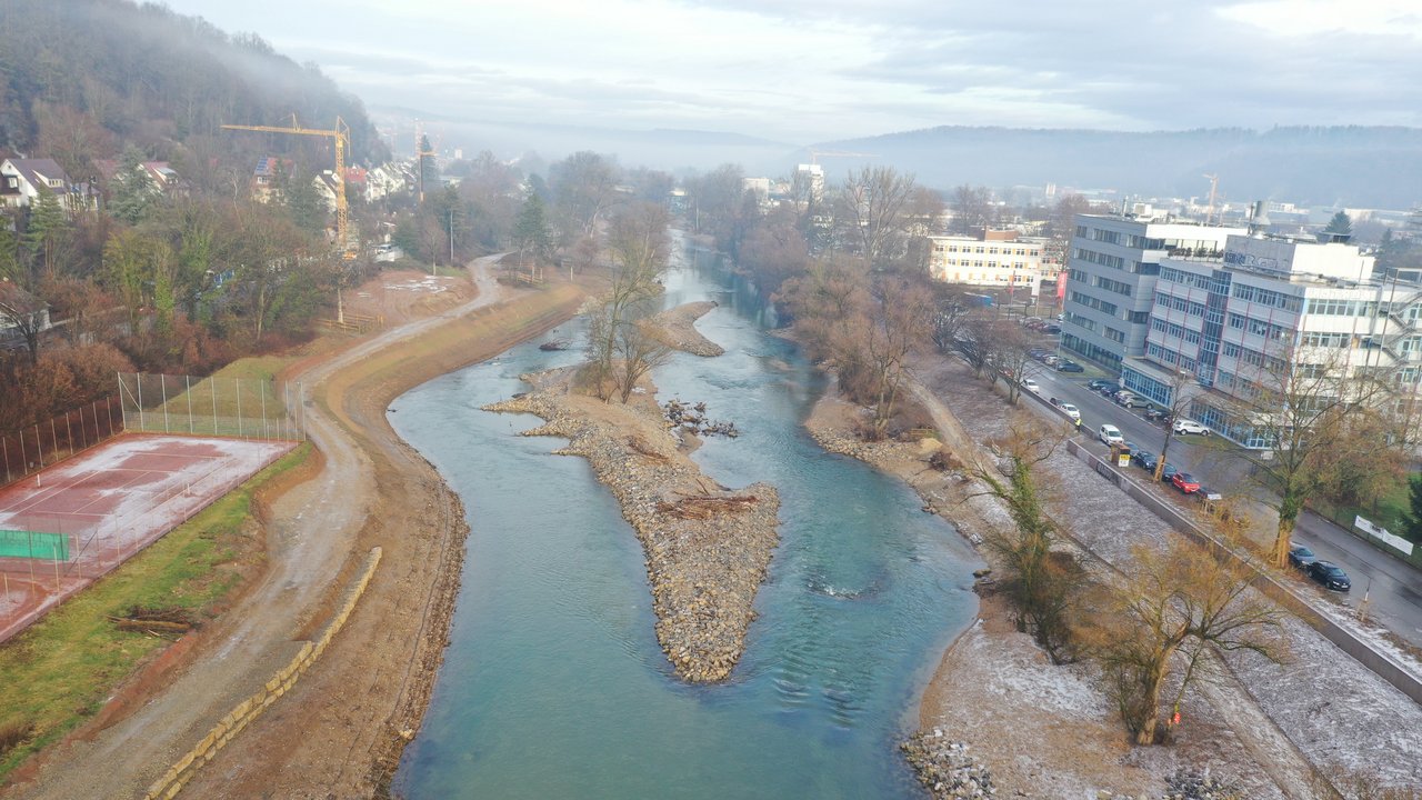 Blick im Januar von oben auf die Baustelle des Flussparks Neckaraue - im Mittelpunkt ist eine Kiesinsel im blauen Neckar zu sehen 